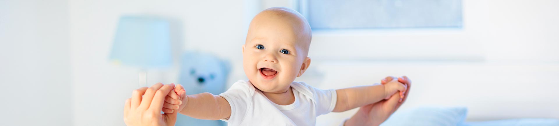 Happy smiling little baby playing with a parent at home.