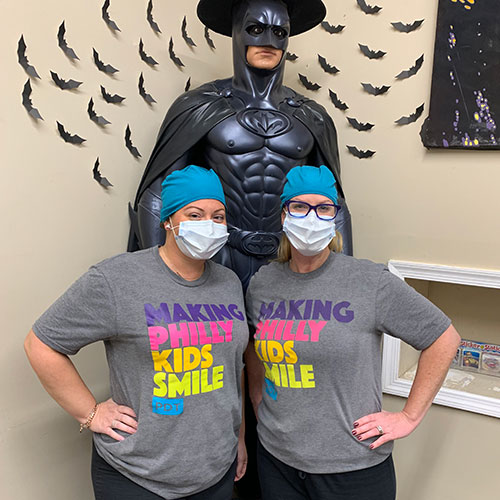 two staff members wearing t-shirts with words: Making Philly Kids Smile