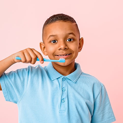 a young boy holding a toothbrush