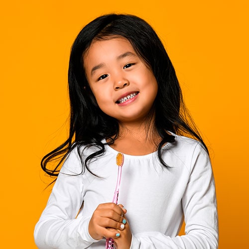 a young asian girl holding a toothbrush