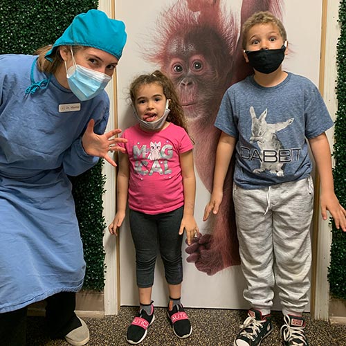 two children and a staff member standing in the hall