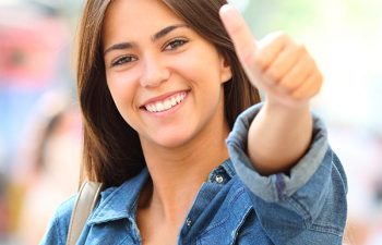 Happy teenage girl showing her thumb up.