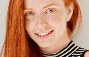 Beautiful red-haired teenage girl with perfect smile.