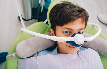 boy getting inhalation sedation while teeth treatment at dental clinic